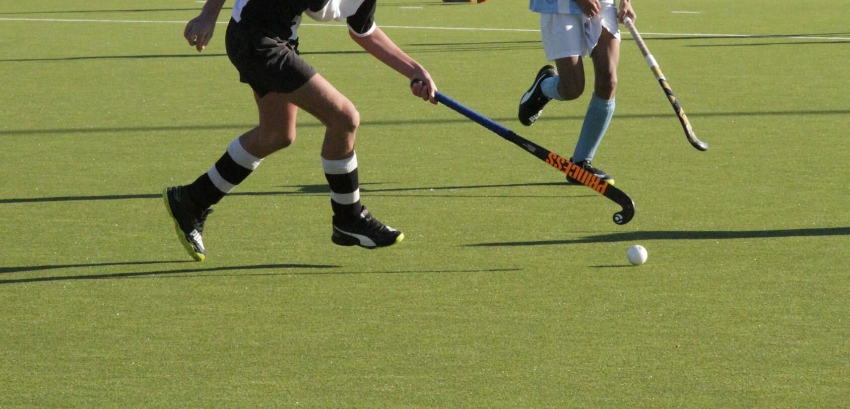 Hockey-Spieler auf einem gr&uuml;nen Feld