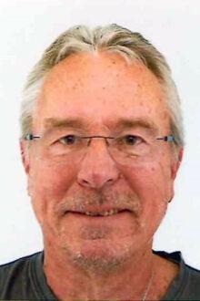 Ein &auml;lterer Mann mit Brille und grauen Haaren l&auml;chelt freundlich in die Kamera. Hintergrund ist neutral hell.