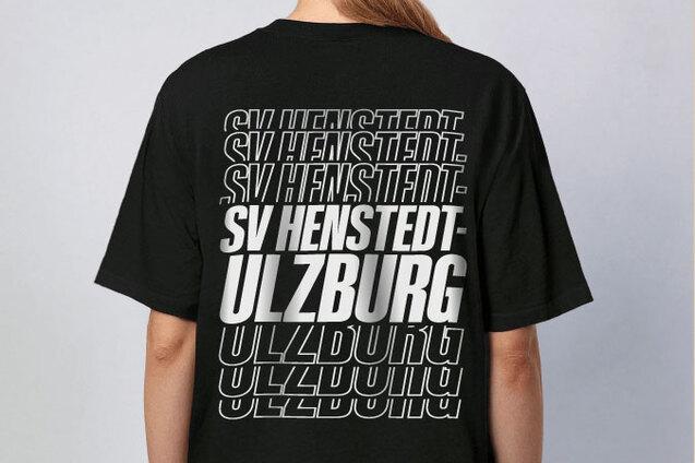 Rückansicht einer Person in schwarzem T-Shirt mit dem Aufdruck „SV Henstedt-Ulzburg“ in verschiedenen Schriftgrößen.